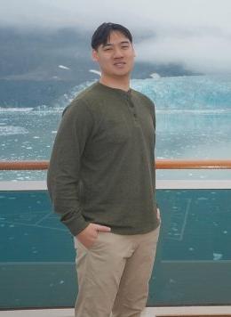 portrait of Ethan Tu on a boat in front of a glacier