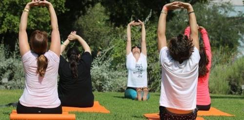 five students do yoga on the mounds