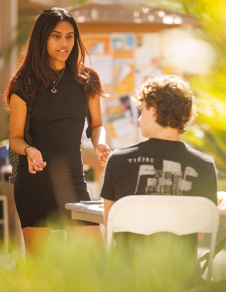 two students have a serious discussion in Scott Courtyard